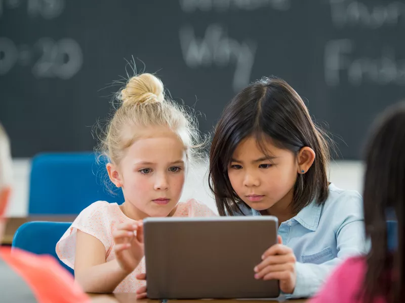 two girls reading on tablet