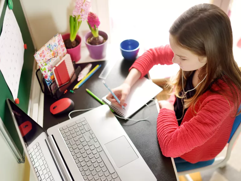 girl doing homework on laptop