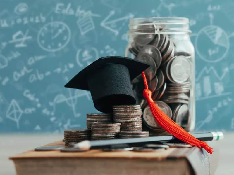 graduate cap next to jar of change