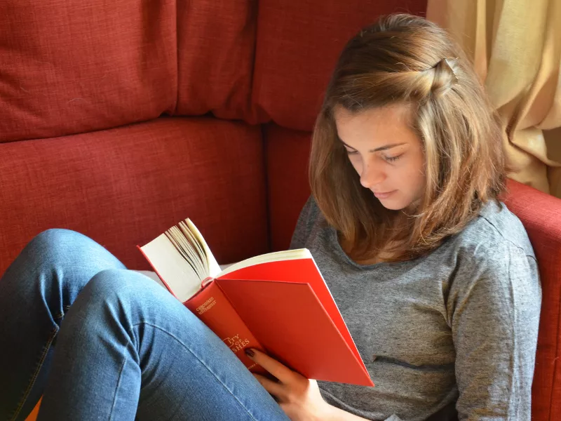teen reading on couch